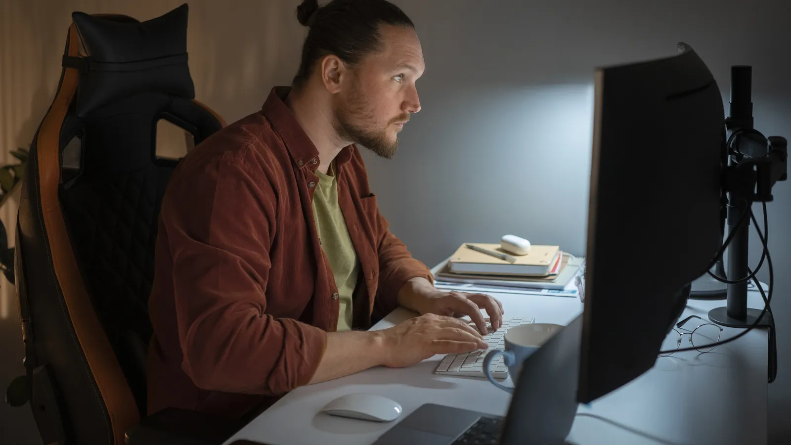 A web developer working on a website migration at a desk late in the evening