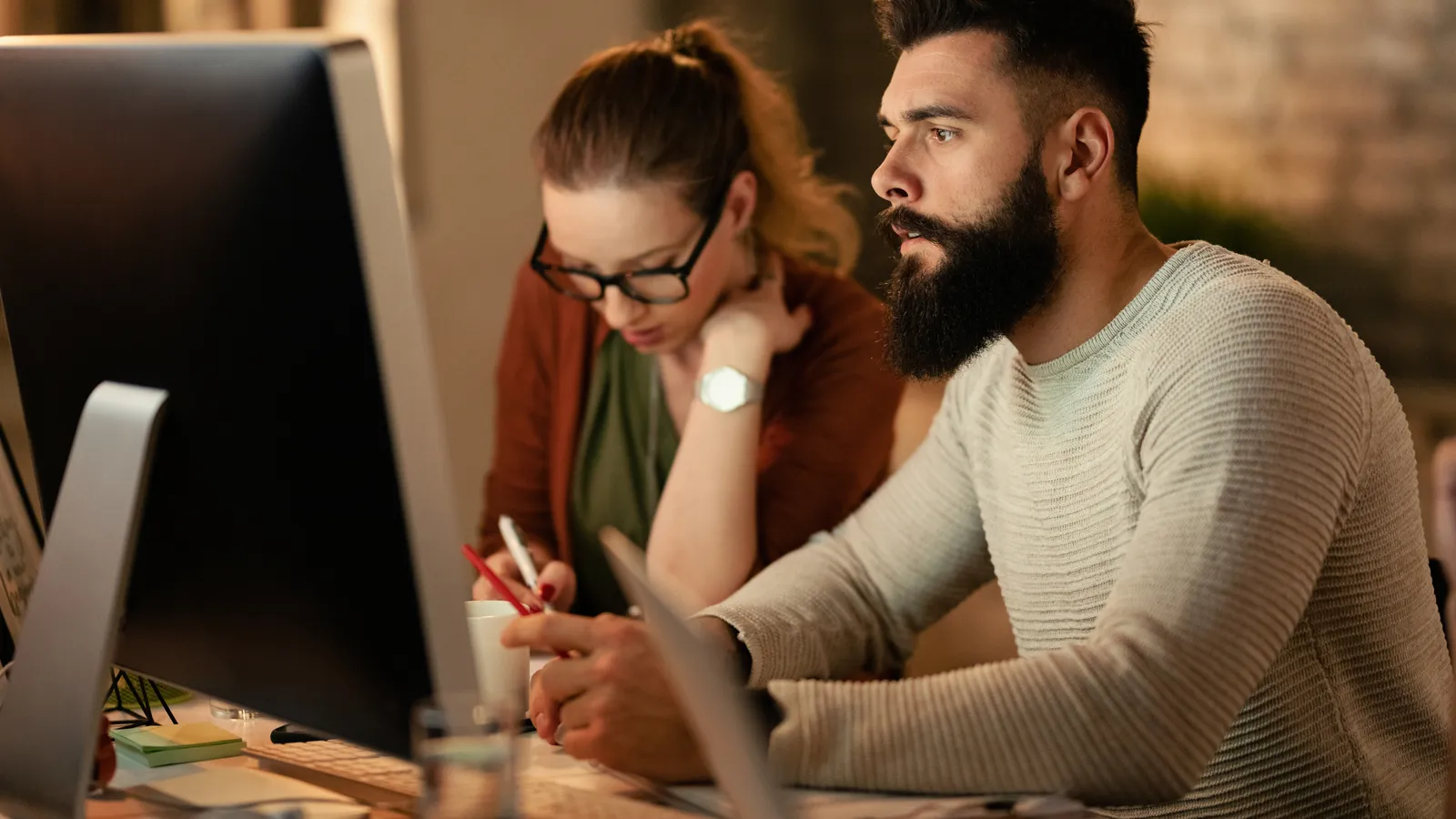 A startup team reviewing their website design together on a large screen